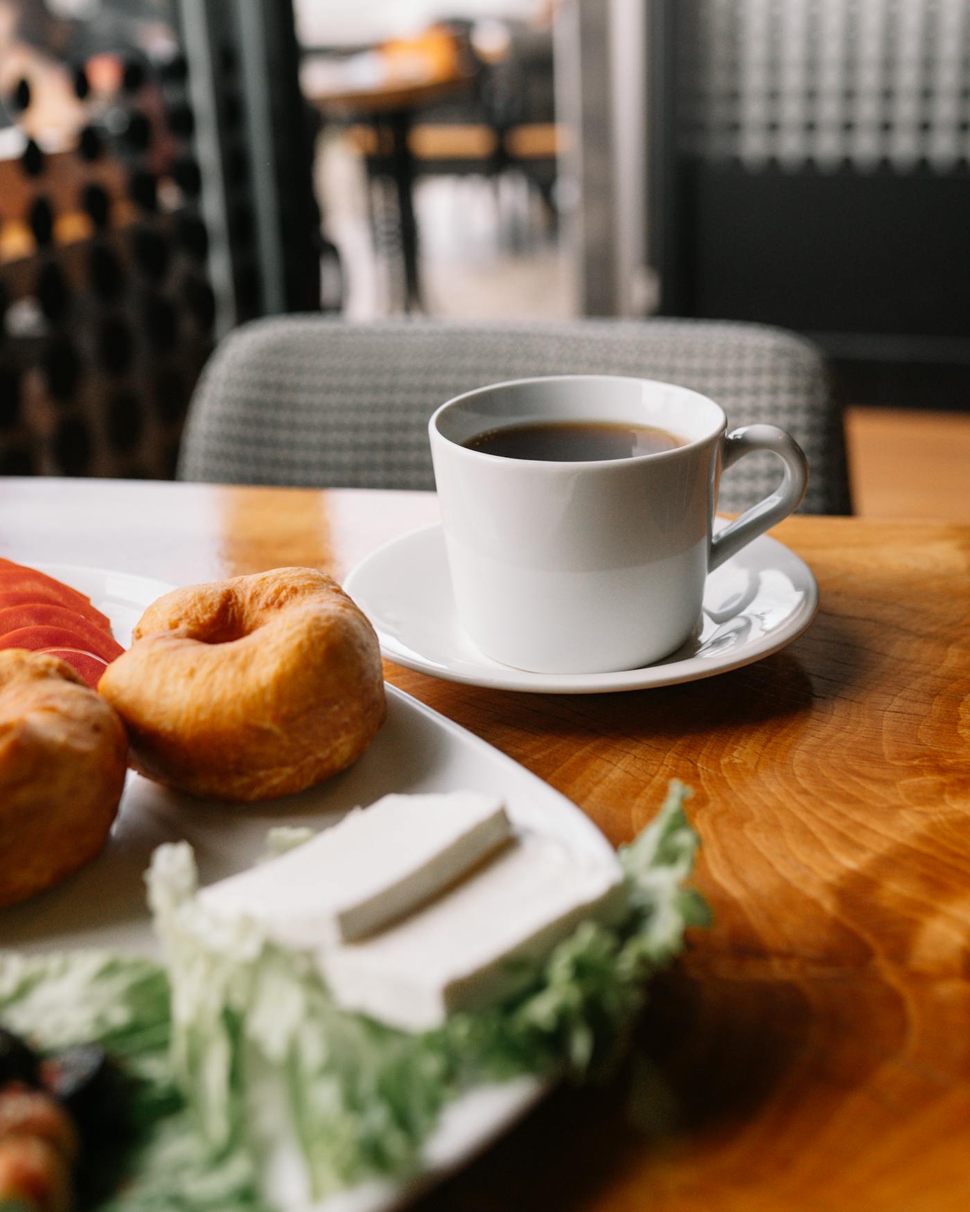 Mesa con café y acompañamiento salado en una cafetería